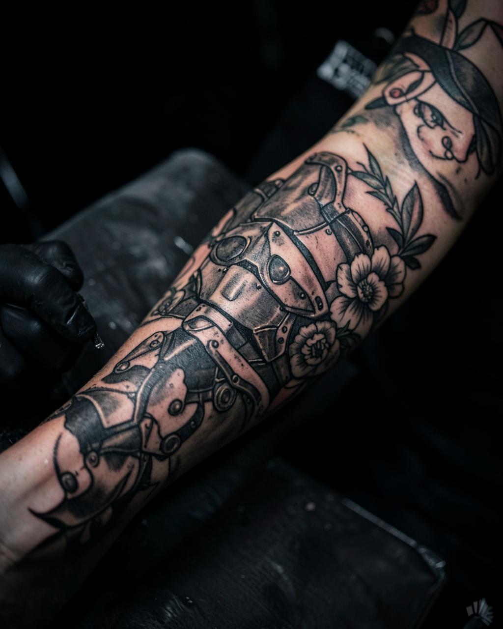 Black and grey mechanical and floral sleeve tattoo in progress
